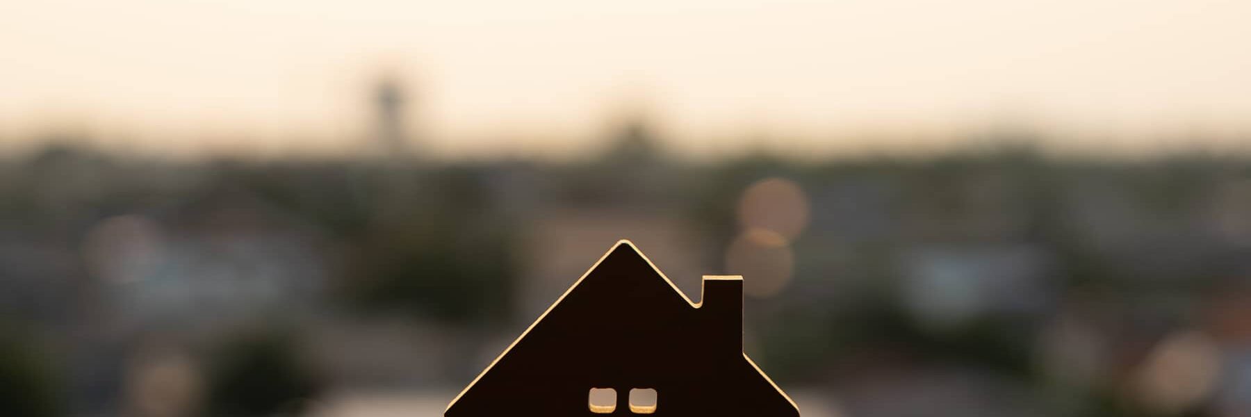 A house figurine with rows of houses in the background.