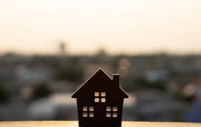 A house figurine with rows of houses in the background.