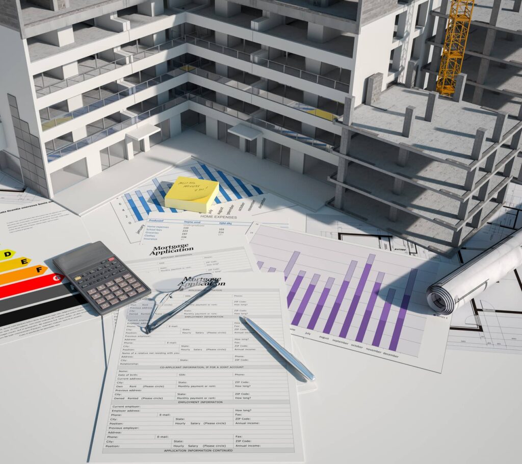 3D model of a property in construction on a table with paperwork.