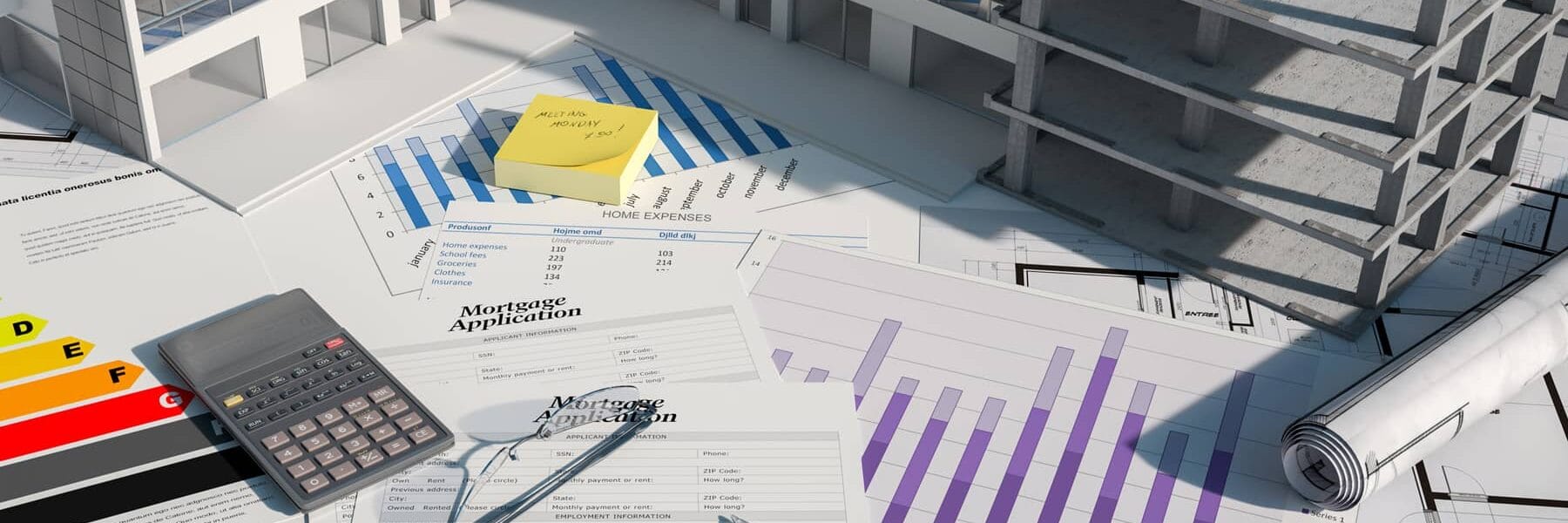 3D model of a property in construction on a table with paperwork.