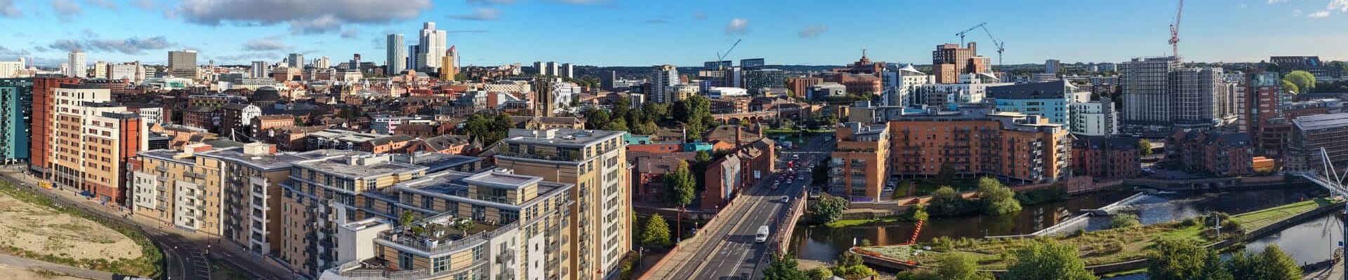 An aerial shot of Leeds' skyline with cranes in the background.